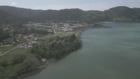 Vista-Aérea-Panorámica-Del-Pueblo-De-Sete-Cidades-Junto-A-Los-Lagos-En-Portugal-Rodeado-De-Exuberantes-Colinas-Verdes