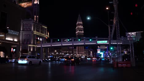 Traffic-on-Las-Vegas-Strip-at-Night,-Venetian-Casino-Hotel-Pedestrian-Bridge-and-Cars