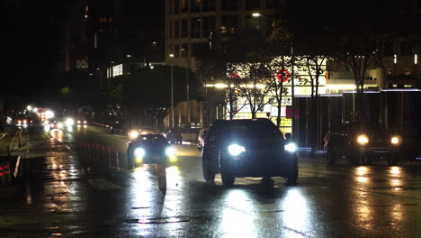 Night-Street-Traffic-in-Downtown-Los-Angeles-USA-After-Rain,-Cars-on-Wet-Road-and-Lights-Reflections