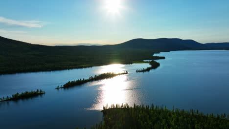 Vista-Aérea-Rodeando-Las-Islas-En-El-Lago-Pallasjarvi,-Con-Páramos-Al-Fondo