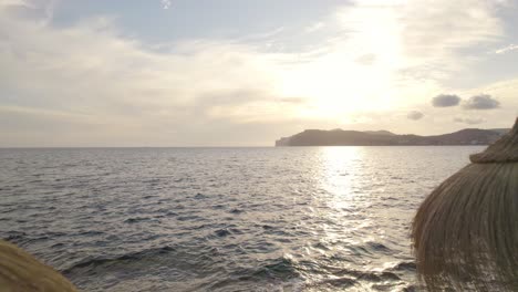 Sonnenschirme-Auf-Einem-Ozeanfelsen-In-Einem-Resort-Auf-Mallorca,-Luftüberflug-Bei-Sonnenuntergang