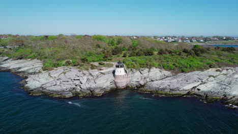 Backward-flight-away-from-Castle-Hill-Lighthouse-over-Narragansett-Bay,-Newport,-RI