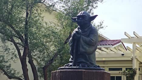 Estatua-De-Yoda-En-Cámara-Lenta,-Primer-Plano-Panorámico-En-El-Campus-De-Cine-De-Lucas-En-San-Francisco,-EE.UU.