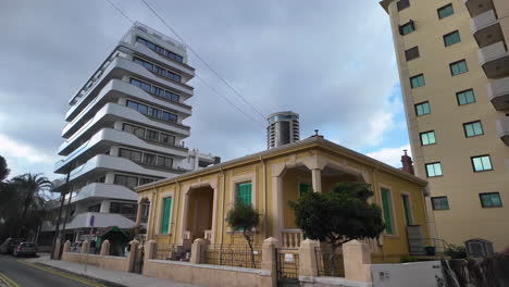 A-modern-bust-statue-in-Nicosia,-Cyprus,-located-in-a-landscaped-area-with-contemporary-buildings-in-the-background