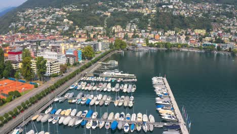 Drone-Del-Puerto-Deportivo-De-Locarno,-Barcos-De-Lujo-Atracados-En-El-Lago-Que-Muestran-El-Encanto-De-Esta-Hermosa-Ciudad-Junto-Al-Lago