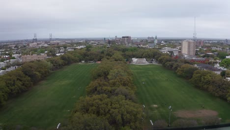 Low-aerial-shot-flying-over-Forsyth-Park-towards-downtown-Savannah,-Georgia