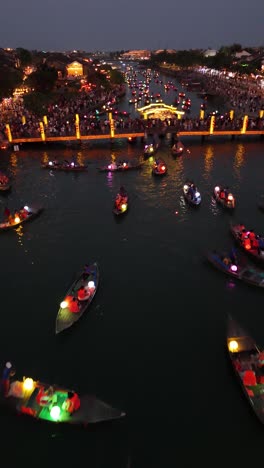 Un-Dron-De-Vuelo-Bajo-Disparó-Sobre-Barcos-Farolillos-Llenos-De-Turistas-Para-La-Hermosa-Celebración-De-Hoi-An-Lantern,-Video-Vertical