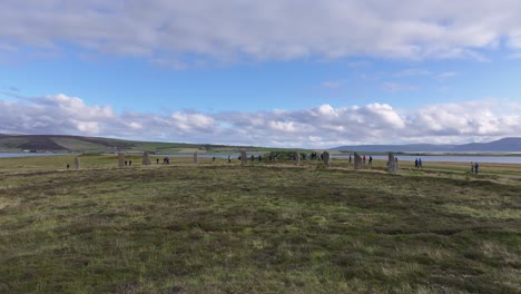 Toma-De-Drones-De-Turistas-Alrededor-Del-Anillo-De-Brodgar-Henge,-Un-Hito-En-El-Paisaje-De-Escocia,-Reino-Unido