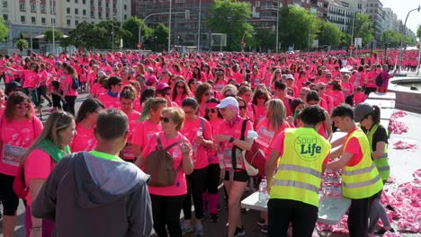 Los-Participantes-Vestidos-Con-Camisetas-Rosas-Se-Hidratan-Durante-La-Carrera-Femenina,-Creando-Conciencia-Sobre-El-Cáncer-De-Mama-Metastásico-En-Madrid,-España.