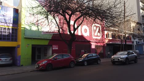 Establishing-shot-Dia-Supermarket-convenience-store-in-Buenos-Aires-City-Streets-autumnal-day-with-cars-passing-by