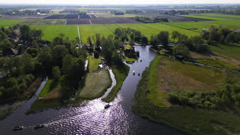 Water-canal-with-boats-and-township-of-Giethoorn-in-Netherlands,-aerial-view