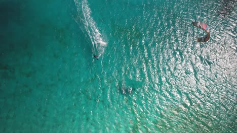 Two-people-kayaking-in-clear-turquoise-waters-of-los-roques,-venezuela,-aerial-view