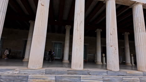 Casual-walk-next-to-Museum-of-Ancient-Agora,-tourists-silhouette-through-Stoa-of-Attalos