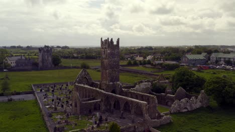 Claregalway-Friary-on-overcast-day-and-Claregalway-castle-on-background,-panoramic-orbit