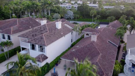 Aerial-tilt-shot-over-a-boat-and-luxury-homes,-sunny-evening-in-Jupiter,-Florida