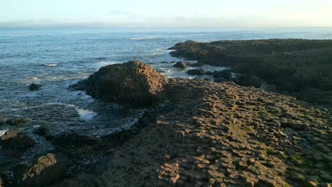 Toma-Aérea-De-Las-Piedras-De-Basalto-En-La-Calzada-Del-Gigante,-Condado-De-Antrim-En-Irlanda-Del-Norte