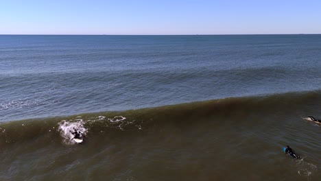 Una-Vista-Aérea-De-Surfistas-Disfrutando-Del-Océano-En-Un-Día-Soleado