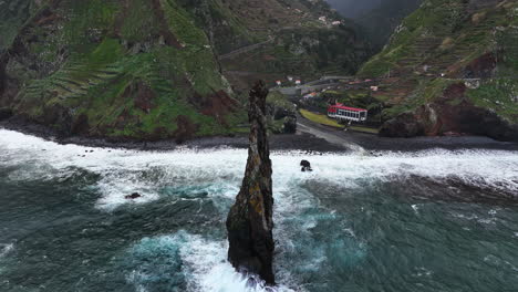 Drone-tilting-away-from-the-Ilheus-da-Rib,-in-cloudy-Ribeira-da-Janela,-Madeira