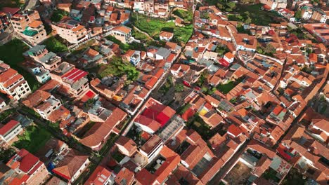 Enjoy-a-stunning-aerial-view-of-Cusco,-showcasing-the-ancient-clay,-Tejas-roofs,-and-green-courtyards-in-full-spring-from-the-San-Blas-lookout