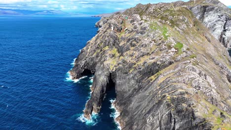 Lugares-épicos-De-Irlanda:-Drones-Volando-Sobre-Enormes-Cuevas-Marinas-Y-Acantilados,-Faro-De-Cabeza-De-Oveja-En-El-Salvaje-Camino-Atlántico