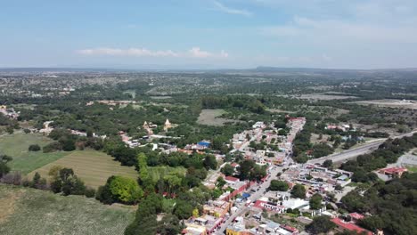 Atotonilco,-mexico,-showcasing-lush-greenery-and-colorful-buildings-on-a-sunny-day,-aerial-view