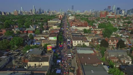 Taste-of-Italy-Along-College-Street-in-Toronto-Overhead-with-Cityscape-Views-from-a-Drone-Dolly-Shot,-Canada