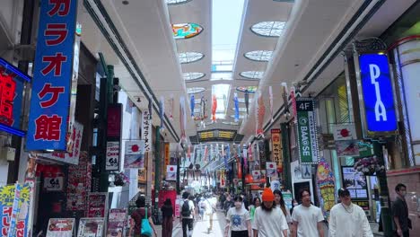 Belebte-Japanische-Einkaufspassage-Mit-Bunten-Schildern-Und-Menschen,-Die-Unter-Einem-Hellen-Oberlicht-Spazieren-Gehen