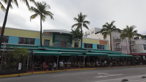 Vibrant-street-scene-in-Miami-Beach-with-colorful-buildings-and-palm-trees-on-a-cloudy-day