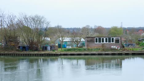 Allotment-gardens,-sheds-and-greenhouses-overlooking-the-River-Thames-in-Oxford-City,-England-UK