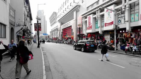 China,-Shanghai:-The-video-captures-a-street-view-in-Shanghai,-showcasing-a-casual-stroll-while-observing-local-shops-and-commerce