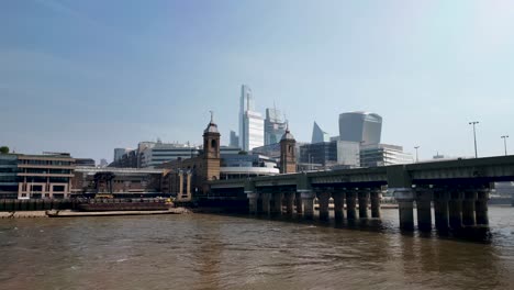 Observar-El-Río-Támesis,-El-Puente-Ferroviario-De-Cannon-Street-Y-El-Horizonte-De-La-Ciudad-De-Londres,-Inglaterra,-Que-Encarna-Una-Fusión-Cautivadora-De-Infraestructura-Urbana-Y-Belleza-Natural.