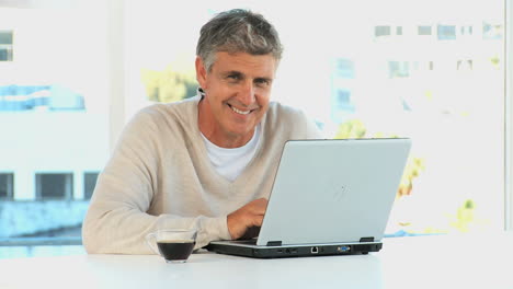 Casual-man-with-a-laptop-looking-at-the-camera