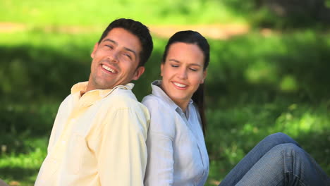 Attractive-couple-sitting-back-to-back