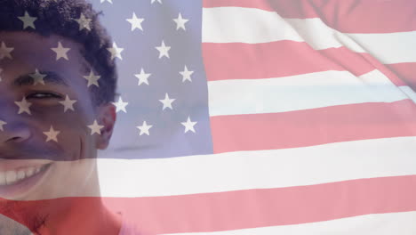 Animation-of-american-flag-over-half-portrait-of-happy-biracial-man-smiling-in-sunshine