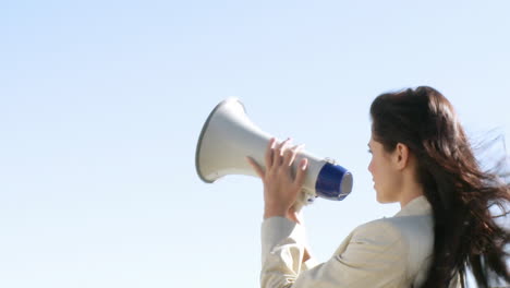 Businesswoman-giving-instruction-via-megaphone