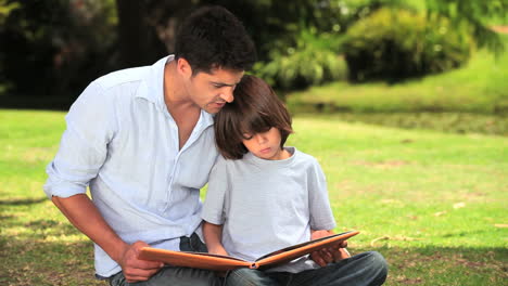 Father-and-son-sitting-reading-outdoors