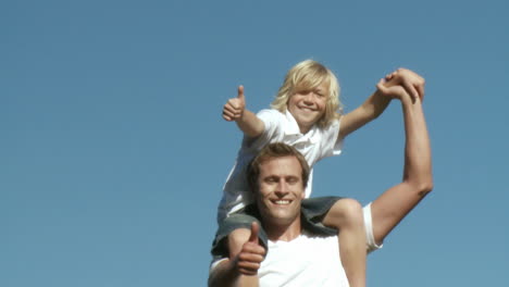 Caring-Father-with-his-son-on-his-shoulders-with-thumbs-up
