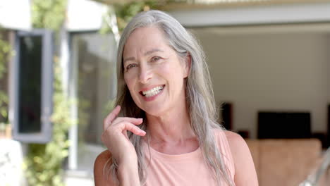 A-mature-Caucasian-woman-with-grey-hair-and-wrinkles-is-smiling