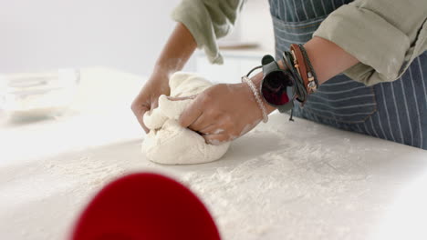 African-American-young-woman-kneading-dough-on-kitchen-counter