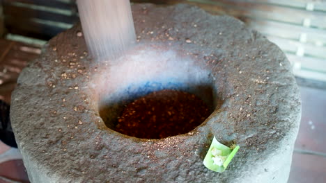 Pounding-Kopi-Luwak-Coffee-Beans-With-Giant-Mortar-And-Pestle