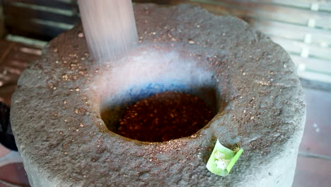 Machacar-Los-Granos-De-Café-Kopi-Luwak-Con-Un-Mortero-Gigante