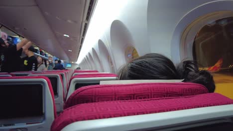 Toma-Panorámica-De-Chinos-Dentro-De-Un-Avión-Colocando-Equipaje-De-Mano-En-La-Cabina-Del-Aeropuerto-De-La-Capital-De-Beijing-Durante-La-Pandemia-De-Covid-19