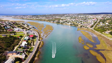 Speedboat-races-up-pristine-Goukou-estuarine-river-in-Still-Bay,-aerial-pullback