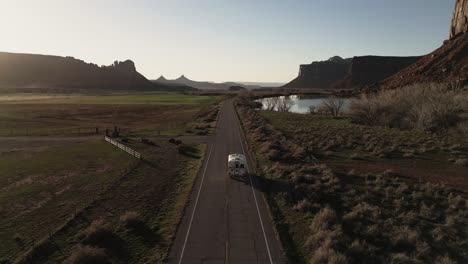 A-van-is-driving-along-the-road-toward-Indian-Creek,-a-renowned-rock-climbing-destination-in-Utah,-USA