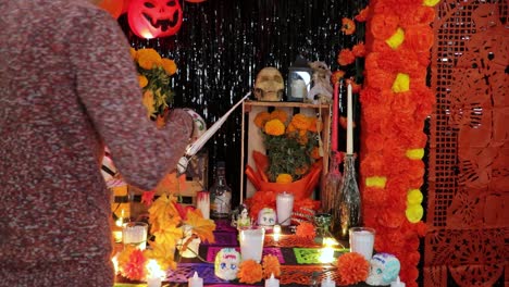 Man-decorating-mexican-Día-de-los-Muertos-altar-with-flower-garland