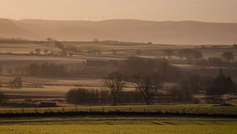 Goldener-Sonnenaufgang-In-Einer-Ländlichen-Gegend-Von-Schottland-Im-Winter-Mit-Windrädern-Am-Horizont,-Perth-Shire,-Großbritannien