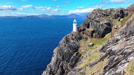 Lugares-épicos-De-Irlanda-Pasos-Rojos-Hacia-El-Faro,-Las-Ovejas-Se-Dirigen-Hacia-El-Oeste-De-Cork-En-El-Camino-Salvaje-Del-Atlántico