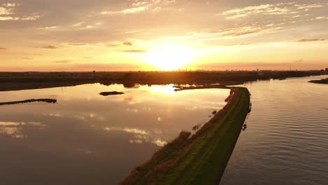 Golden-sky-cloud-morning-sunrise,-still-water-reflection,-horizon,-aerial