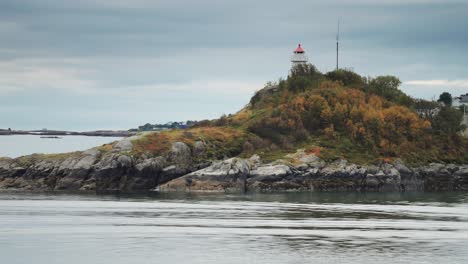 Un-Faro-En-Miniatura-En-La-Pequeña-Isla-Rocosa-Cubierta-De-Hierba