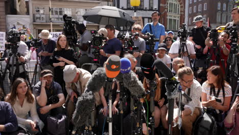 Members-of-the-press,-photographers-sitting-and-television-camera-operators-standing,-wait-for-the-start-of-a-press-conference